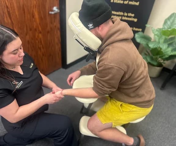 Therapist treating a patient's wrist and forearm for carpal tunnel symptoms at Back in Action Chiropractic in Las Vegas