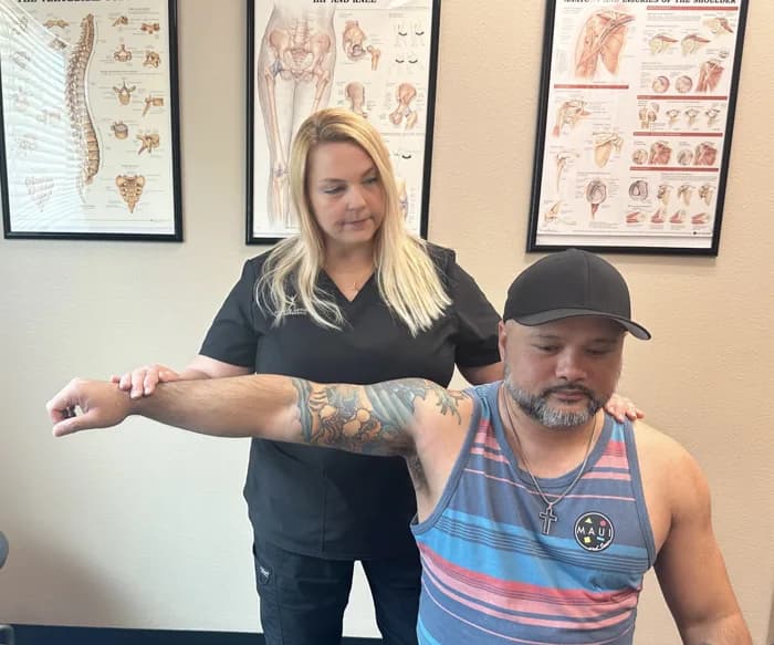 Dr. Michelle Binkowski assessing a patient's shoulder range of motion at Back in Action Chiropractic in Las Vegas