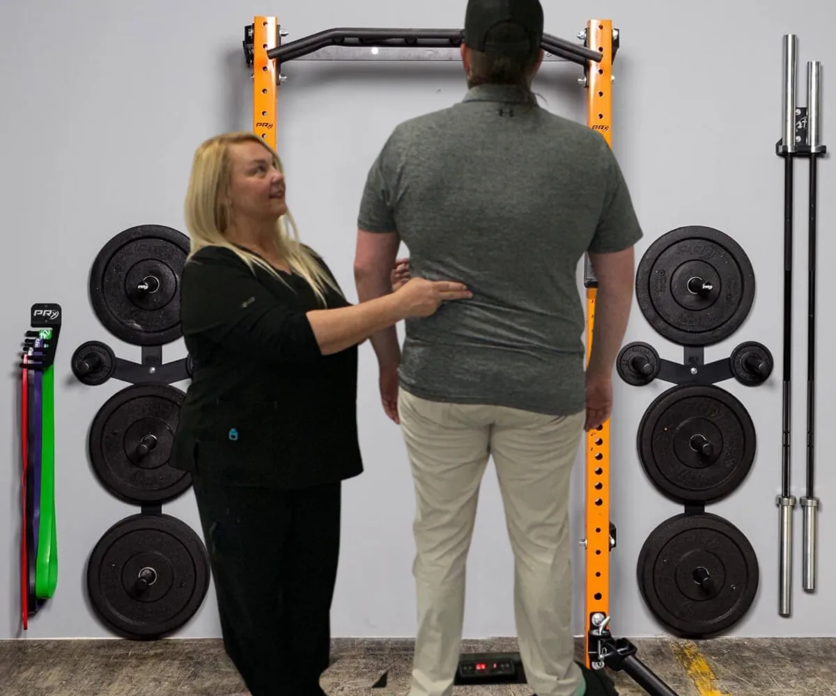 Dr. Michelle Binkowski assessing an athlete's posture and alignment at a Las Vegas training facility