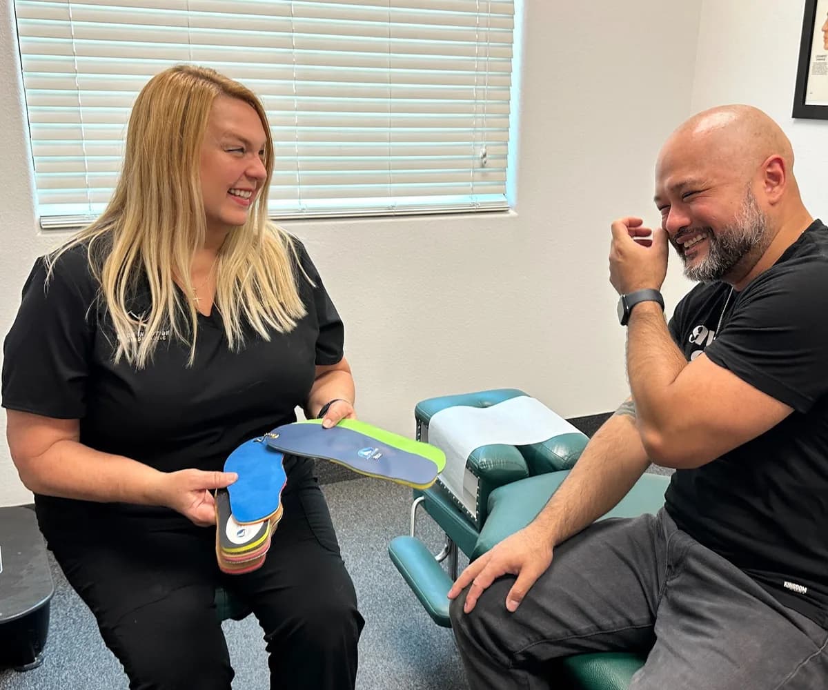 Dr. Michelle Binkowski showing custom orthotic insoles to a patient at Back in Action Chiropractic in Las Vegas