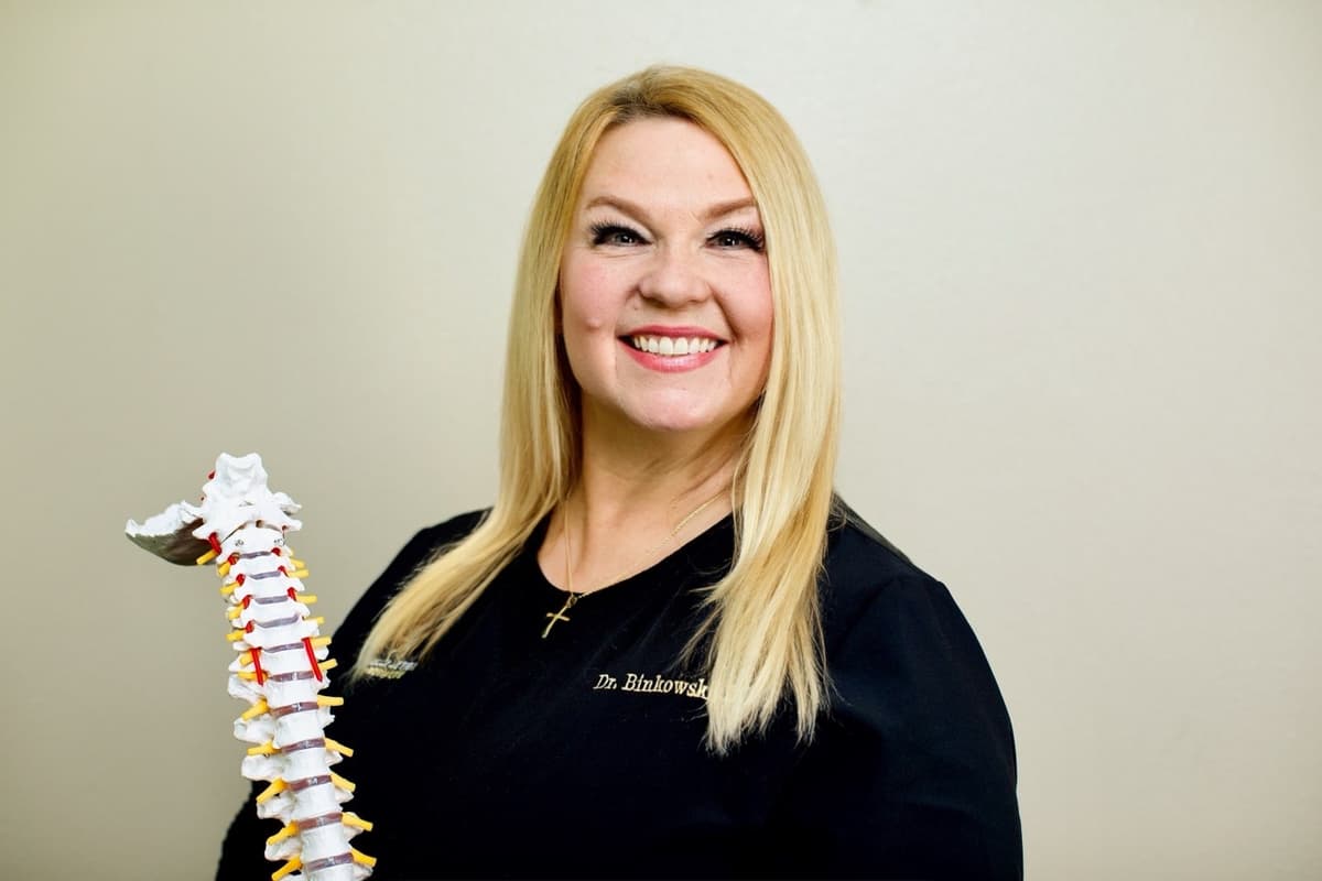 Dr. Michelle Binkowski holding a spine model